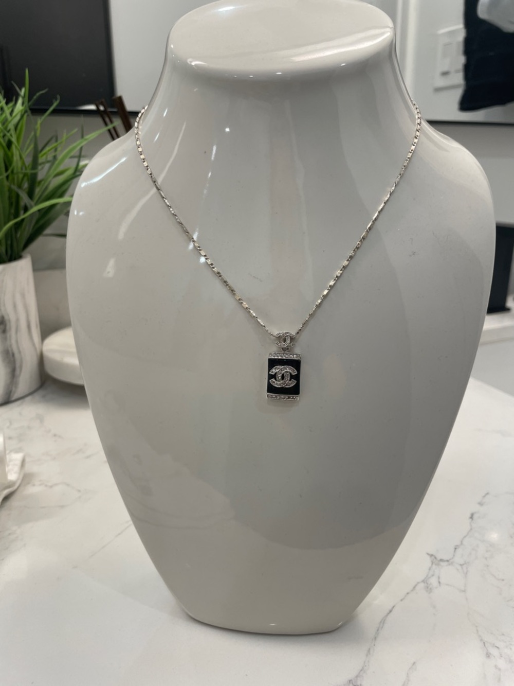 CHANEL Silver/ diamond pendent with Black Logo Plaque.